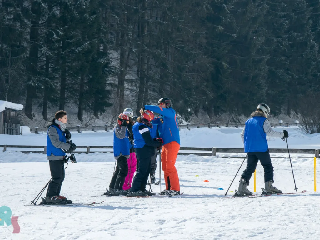 Skigruppe steht an der Absperrung beisammen.